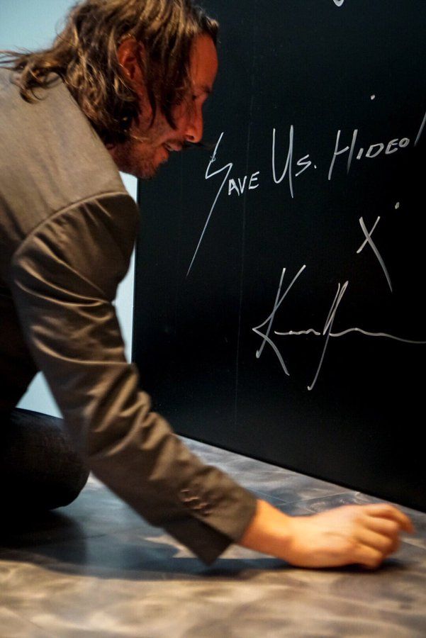 Киану Ривз оставляет подпись на стене для гостей | Источник: twitter.com/HIDEO_KOJIMA_EN