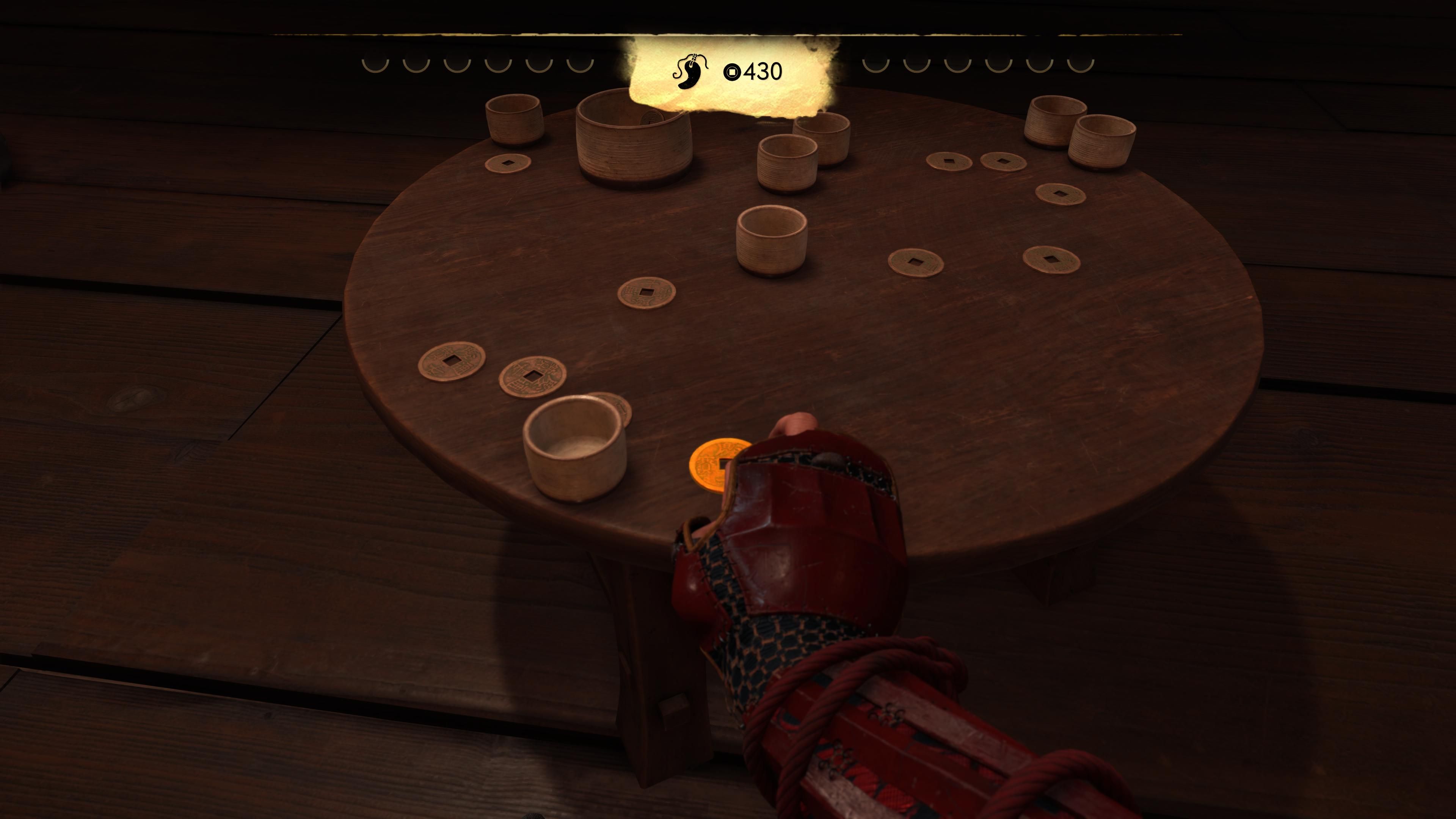В трактире можно поиграть в азартную игру с монетками: если аккуратно выбить все монетки, дадут оберег. Скриншот из Ghost of Yōtei