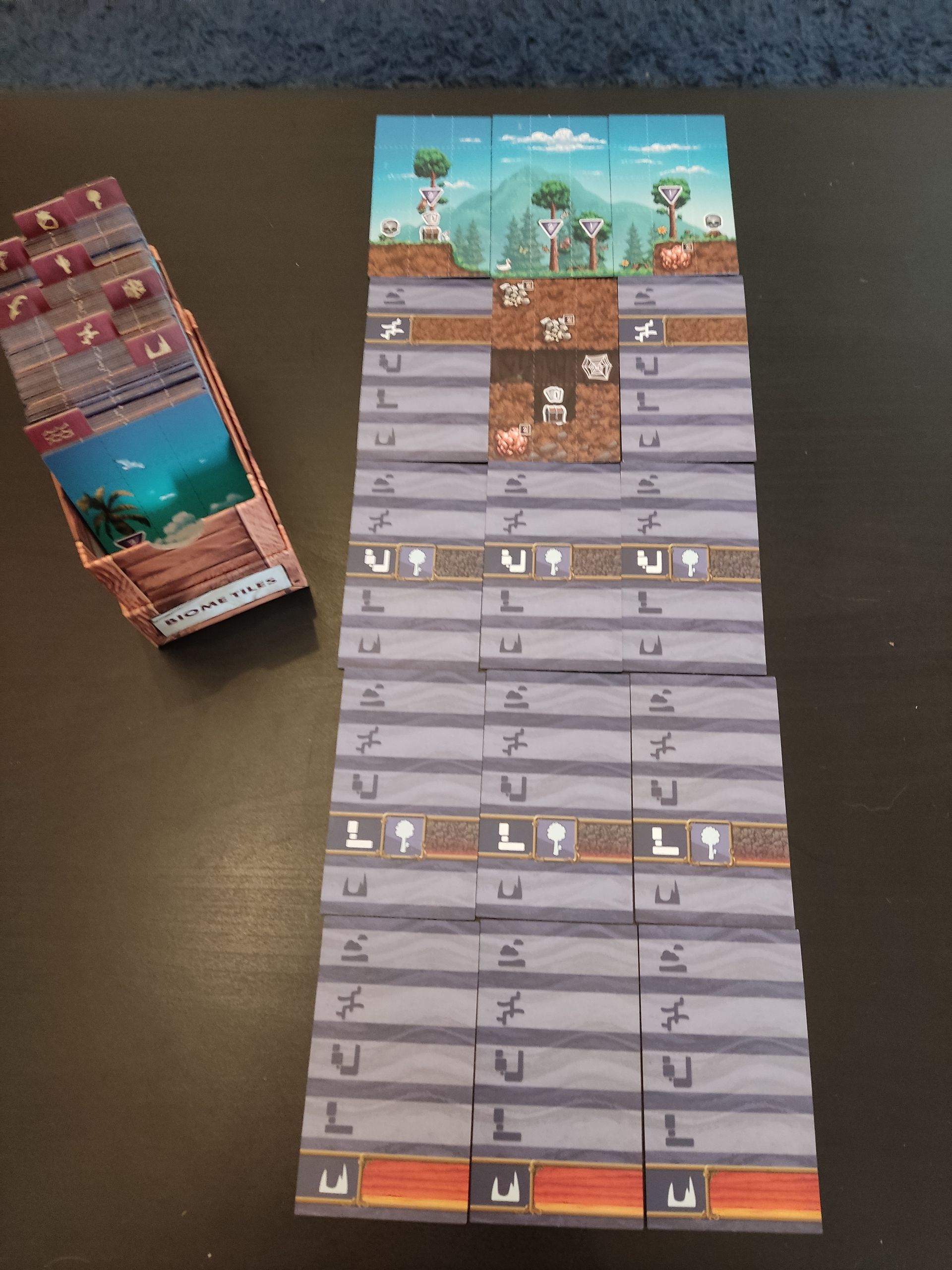 Вот так выглядит полный биом. Я специально разложил тайлы рубашкой вверх, чтобы рассказать о системе координат в Terraria. В картотеке слева всё разбито по биомам, к которым относятся тайлы поверхности и пещер третьего и четвёртого уровней. Тайлы из второго и пятого рядов на фото фактически составляют свои отдельные категории и подходят к любым биомам.