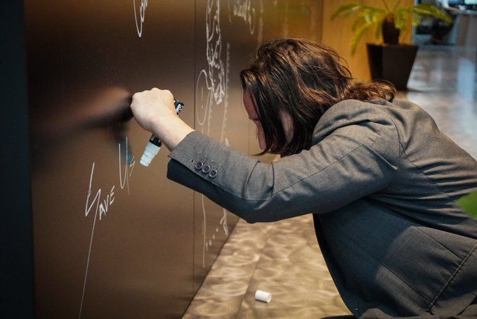 Киану Ривз оставляет подпись на стене для гостей | Источник: twitter.com/HIDEO_KOJIMA_EN