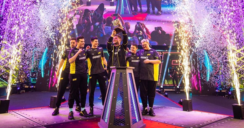 команда киберспортсменов на сцене с кубком