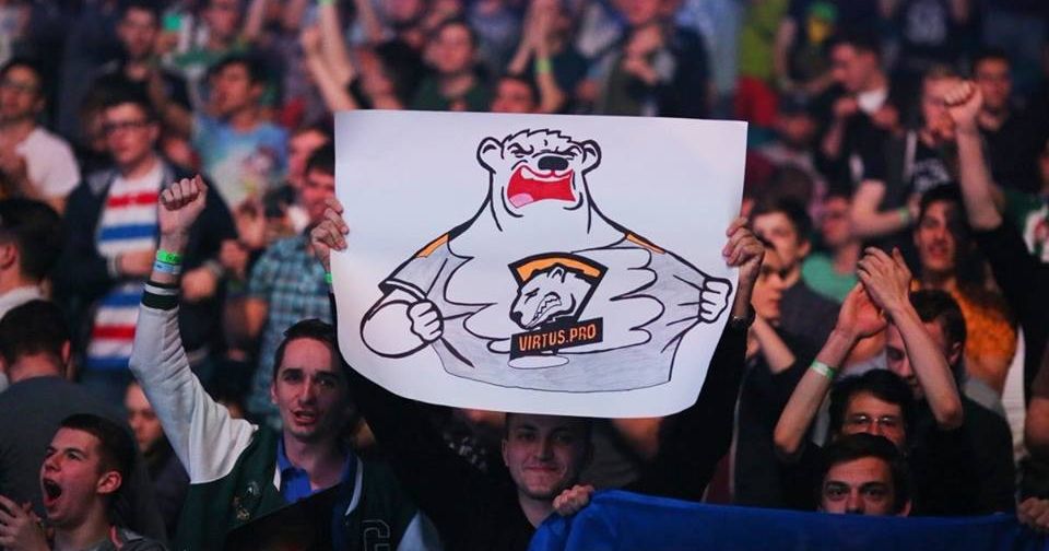 толпа фанатов с плакатами на киберспортивной арене